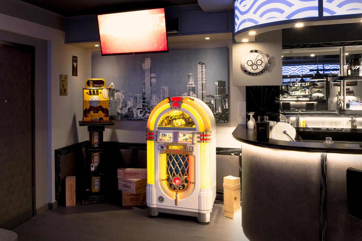 Un jukebox, una slot machine vintage e un televisore estraibile a soffitto
