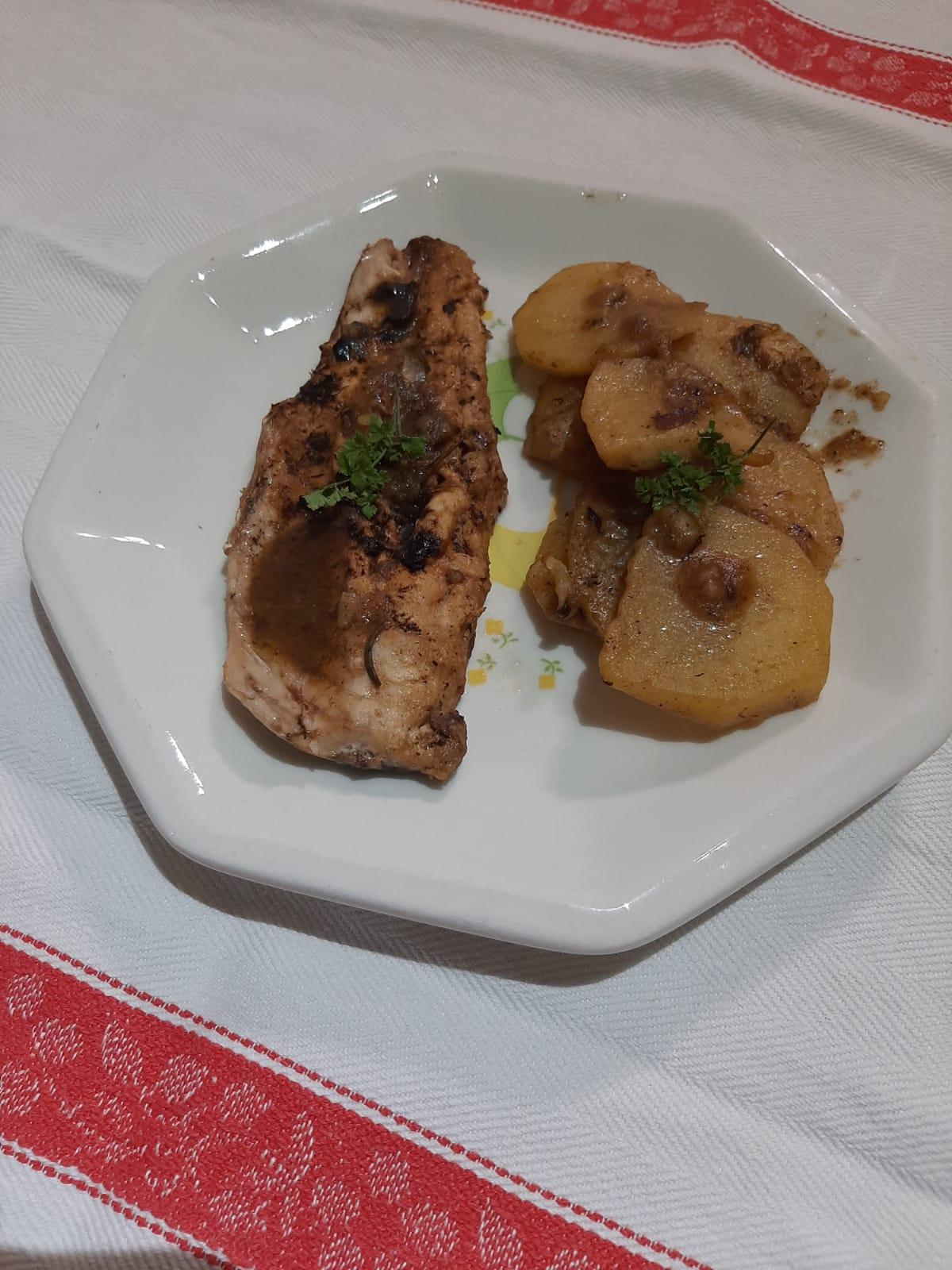 Teller mit Kabeljaufilet und neuen Kartoffeln mit schwarzem Knoblauch Italien