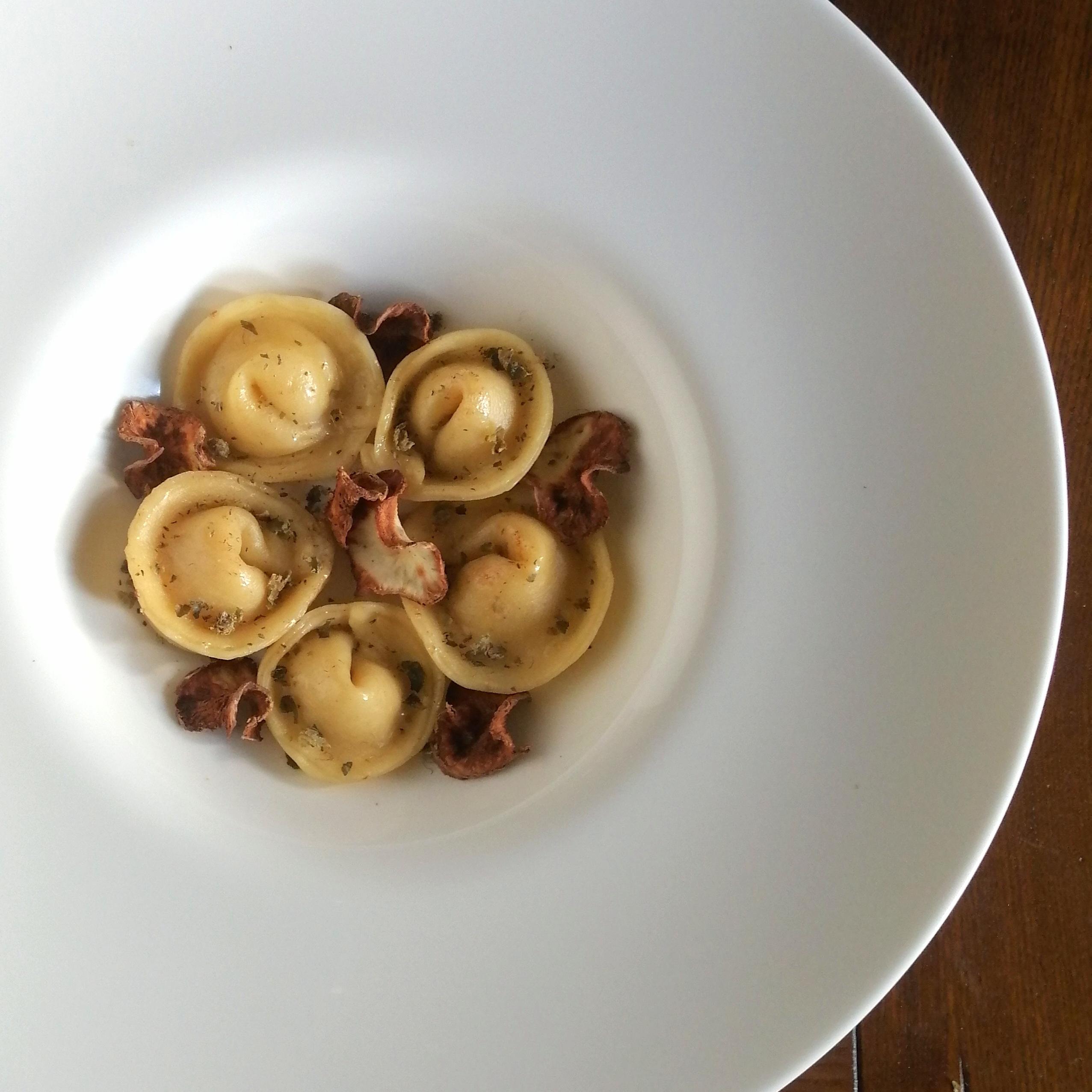 Girotondo di tortelli al caprino e topinambur con crumble di capperi e chips di topinambur