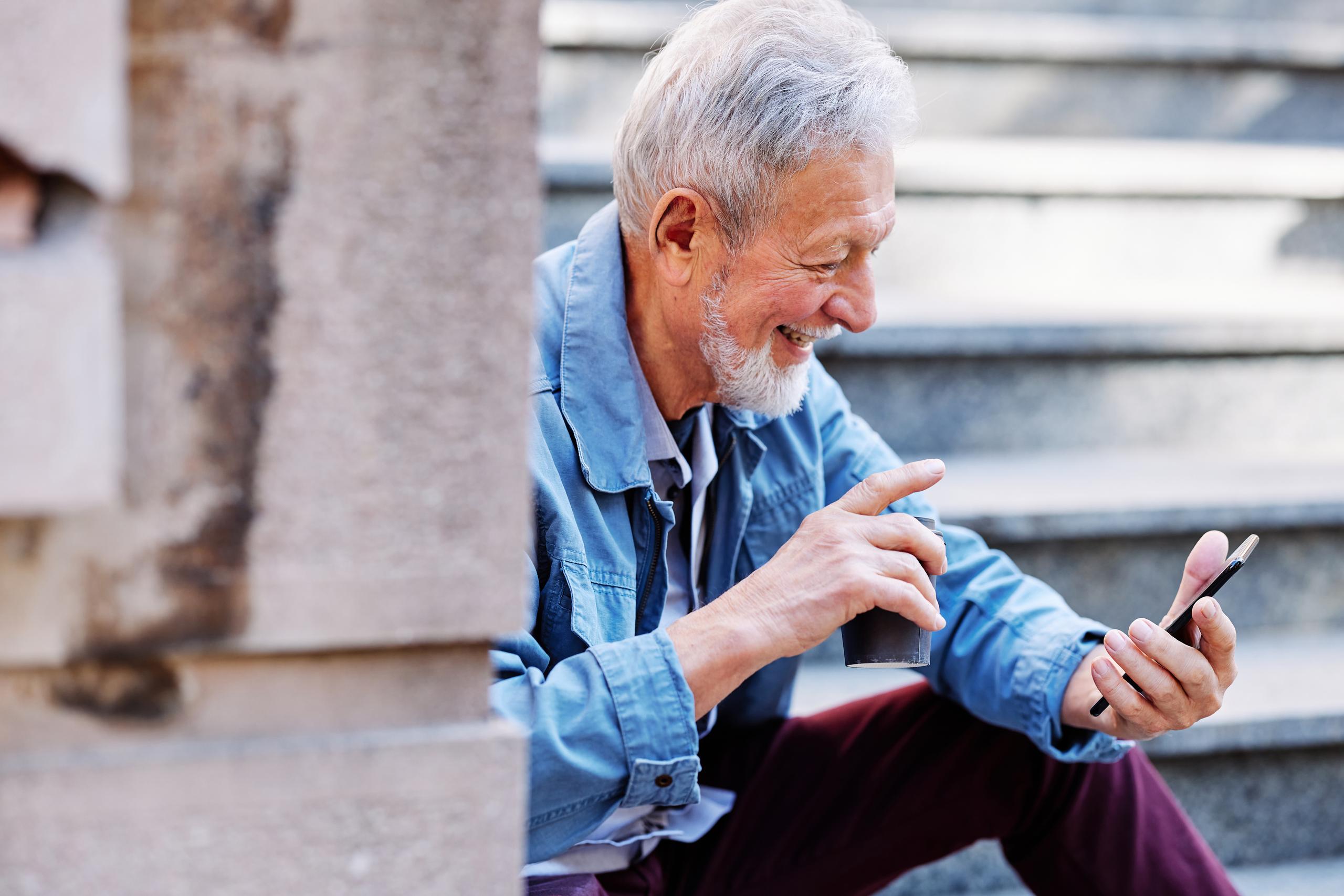 Immagine di un signore con in mano un telefono