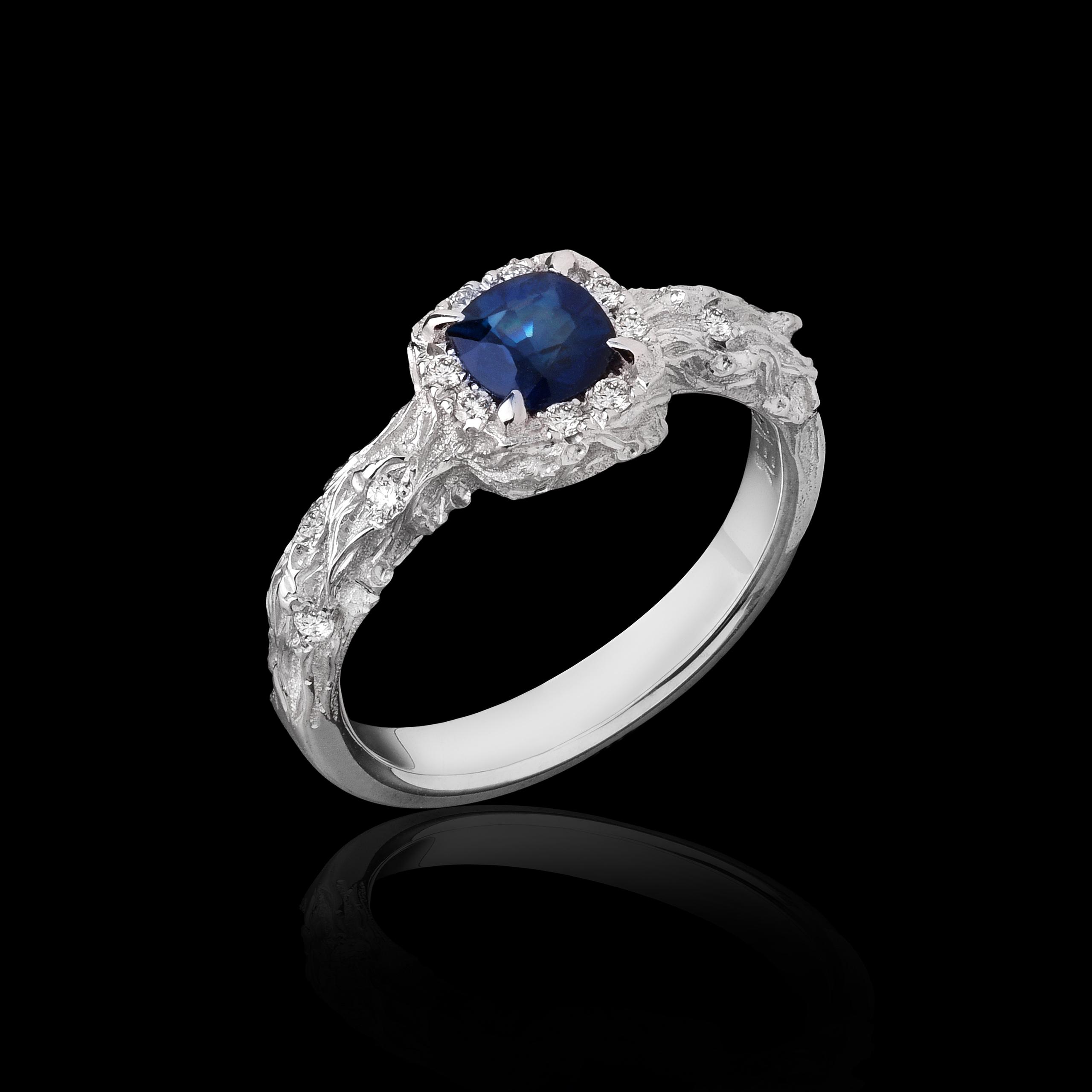 18kt white gold, blue sapphire center stone with 8 natural diamonds framing and 6 on the band