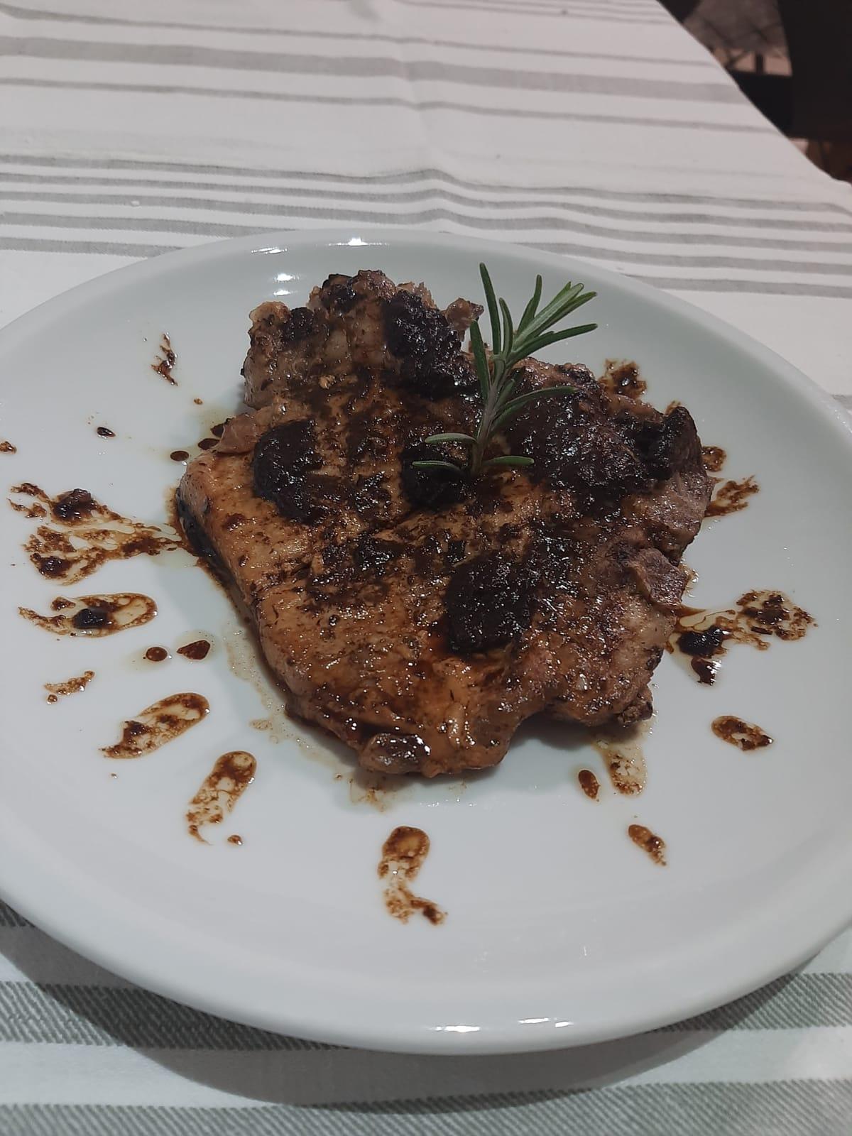 Pork steak plate with black garlic Italy