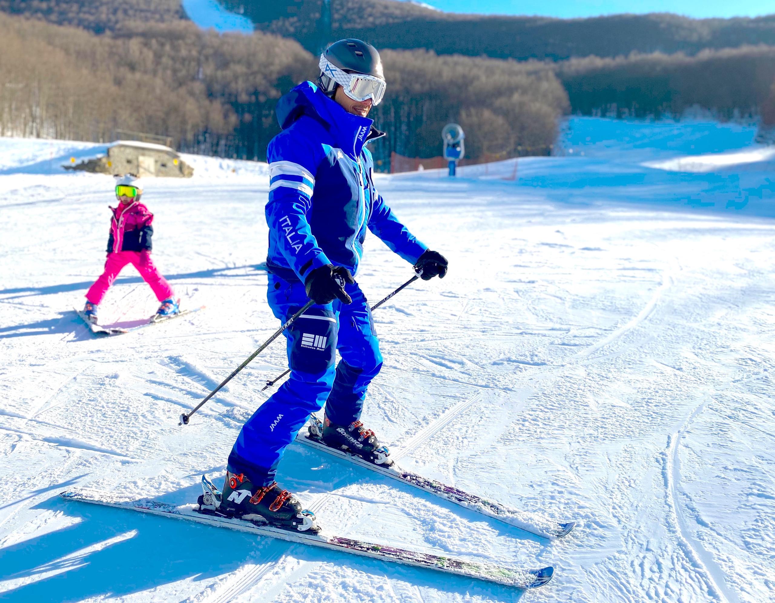 Italienischer Skilehrer mit dem Elettronica Monti Logo auf dem Skianzug