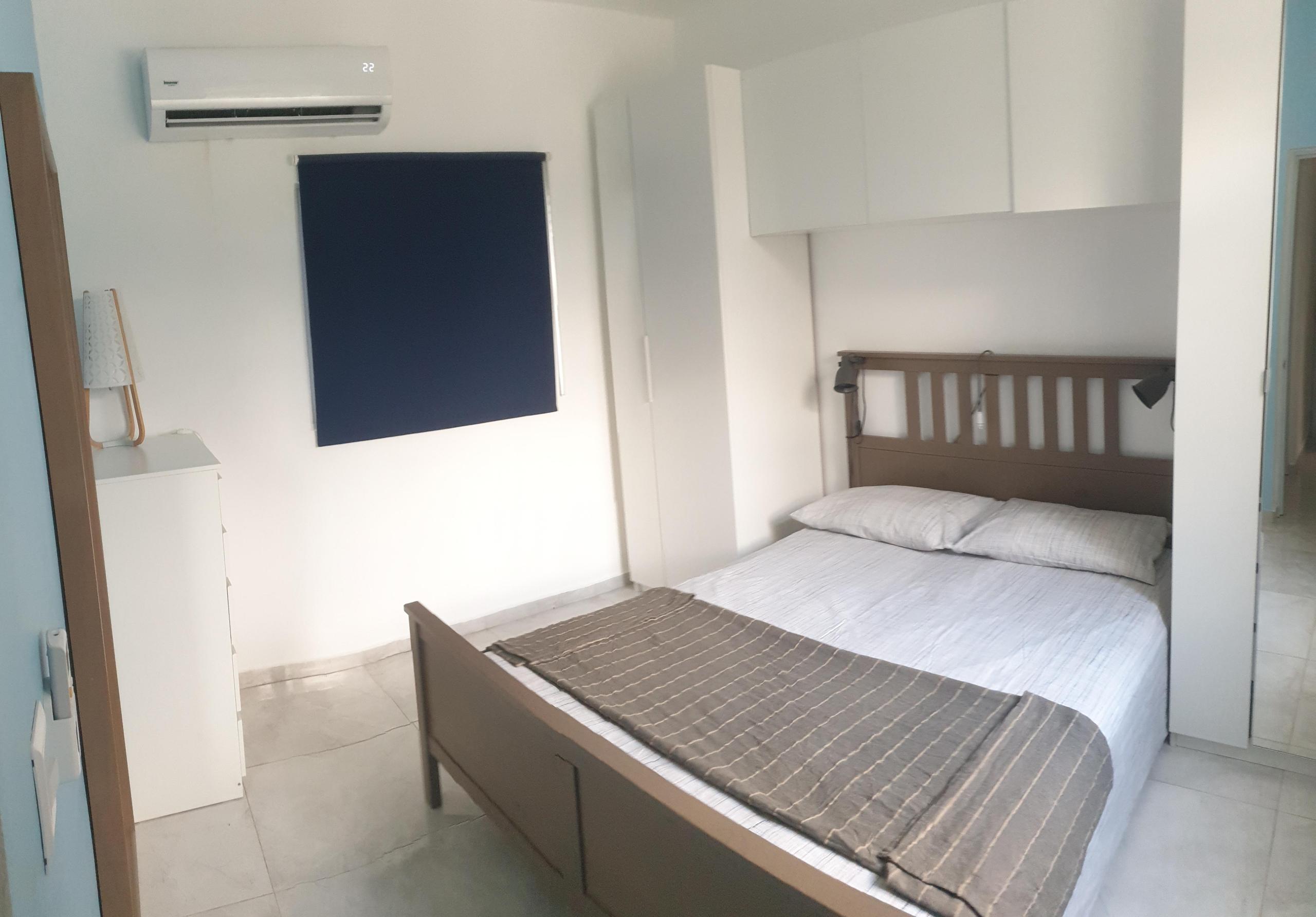 Camera da letto con tende oscuranti, aria condizionata e ventilatore a soffitto