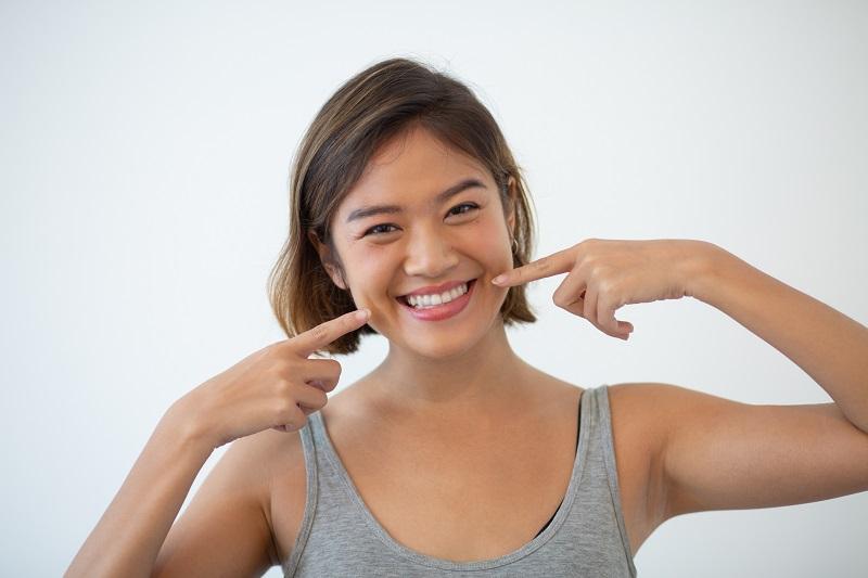 smiling-pretty-asian-woman-pointing-at-her-teethjpg