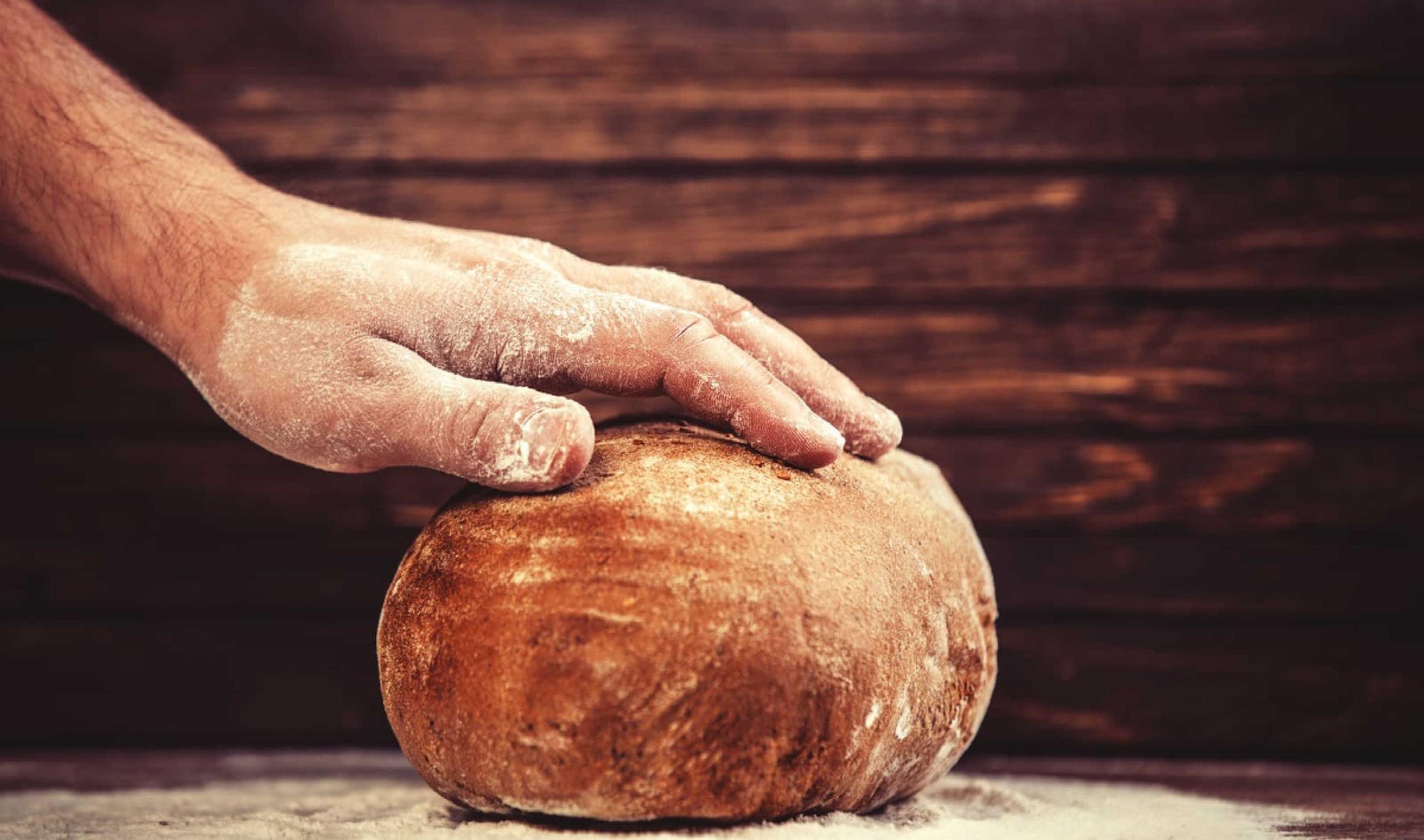 Mano sul pane appena sfornato ancora caldo