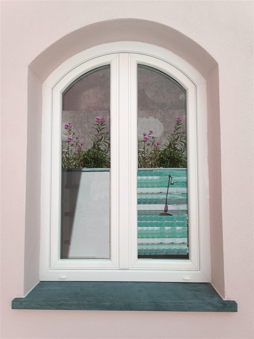 Finestra ad arco centinato, realizzata in pvc a due ante con vetri ad altissime prestazioni
