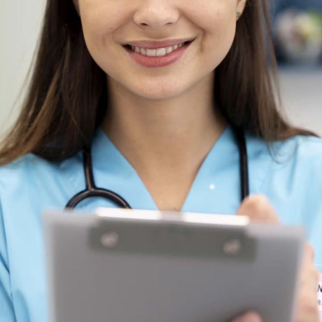 immagine di una donna che guarda sorridente il suo apparecchio acustico assieme a un audioprotesista